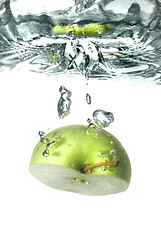 Image showing green apple dropped into water with splash isolated on white