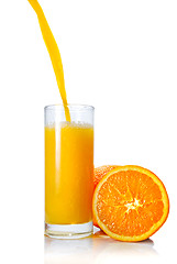 Image showing orange juice poring into glass isolated on white