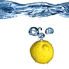 Image showing Fresh lemon dropped into water with bubbles isolated on white