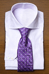 Image showing shirt with violet tie on wooden shelf