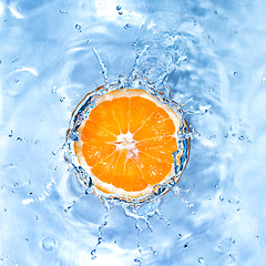 Image showing Fresh orange dropped into water with bubbles isolated on white