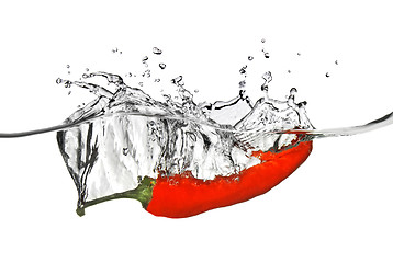 Image showing red pepper dropped into water with splash isolated on white