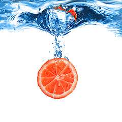 Image showing Fresh grapefruit dropped into water with bubbles isolated on whi