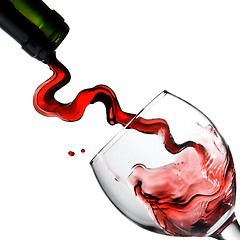 Image showing Pouring red wine in glass goblet isolated on white