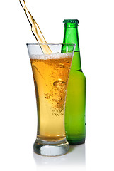 Image showing Beer pouring from into glass isolated with bottle on white