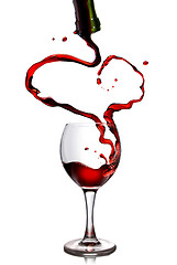 Image showing Red wine pouring in goblet from bottle in shape of heart