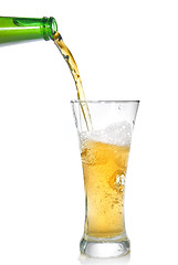 Image showing Beer pouring from bottle into glass isolated on white