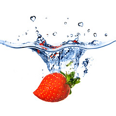 Image showing heart from strawberry dropped into water with splash isolated on