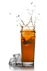 Image showing Beautiful splash of cola in glass and ice cubes isolated on whit