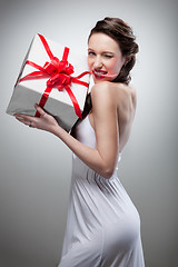 Image showing Young smiling woman holding gift