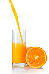 Image showing orange juice poring into glass isolated on white