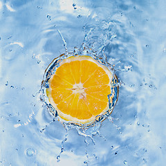 Image showing Fresh lemon dropped into water with bubbles isolated on white