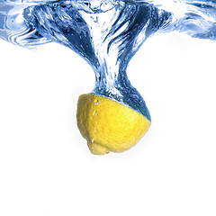 Image showing Fresh lemon dropped into water with bubbles isolated on white