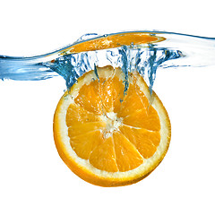 Image showing Fresh orange dropped into water with splash isolated on white