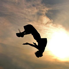 Image showing silhouette of jumping man against sky and clouds