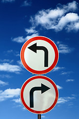 Image showing two opposite road signs against blue sky and clouds