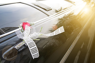 Image showing Door of black wedding car with flower and ribbon