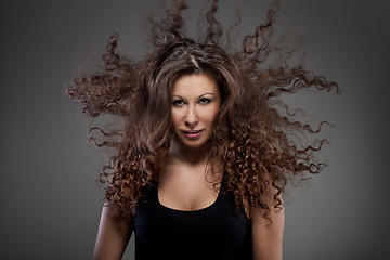 Image showing portrait of beautiful woman with curly hair in air
