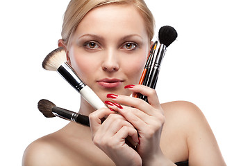 Image showing Young woman with make up brushes isolated on white