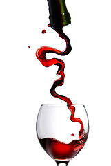 Image showing Pouring red wine in glass goblet isolated on white