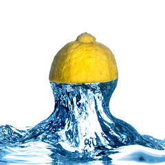 Image showing Fresh lemon dropped into water with splash isolated on white