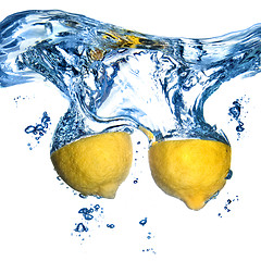 Image showing Fresh lemon dropped into water with bubbles isolated on white