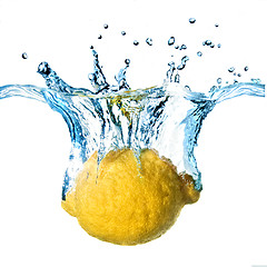 Image showing Fresh lemon dropped into water with splash isolated on white