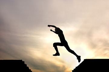 Image showing silhouette of jumping boy agains