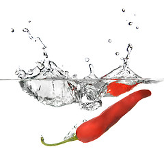 Image showing red pepper dropped into water with splash isolated on white