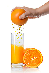 Image showing squeezing orange juice pouring into glass isolated on white