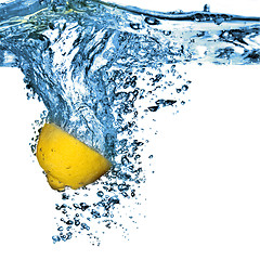 Image showing Fresh lemon dropped into water with bubbles isolated on white