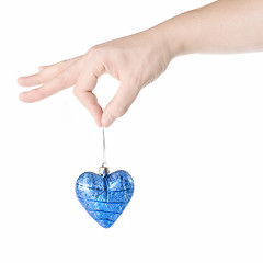 Image showing arm holding blue christmas ball in shape of heart isolated on wh