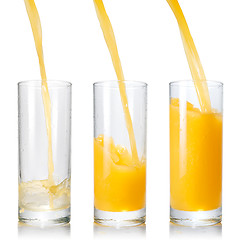 Image showing Pouring orange juice into the glass isolated on white