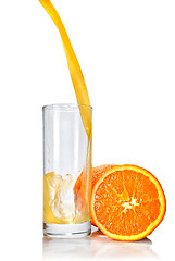 Image showing orange juice poring into glass isolated on white