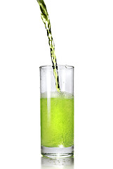 Image showing green juice pouring into glass isolated on white