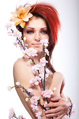 Image showing Portrait of beautiful naked woman with spring flower in hair on white