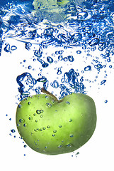 Image showing green apple dropped into water with bubbles isolated on white