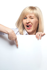 Image showing Attractive funny woman holding white empty paper and pointing on