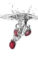 Image showing plum dropped into water with bubbles isolated on white