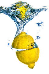 Image showing Fresh lemon dropped into water with bubbles isolated on white