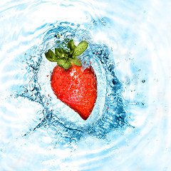 Image showing heart from strawberry dropped into water with splash isolated on