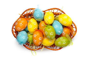 Image showing color easter eggs in basket isolated on white. top view