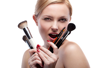 Image showing Young smiling woman with make up brushes isolated on white