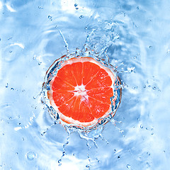 Image showing Fresh lemon dropped into water with bubbles isolated on white