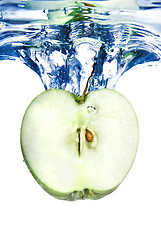 Image showing green apple dropped into blue water with splash isolated on whit