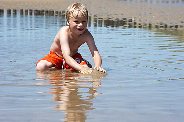 Image showing Boy plays with sand