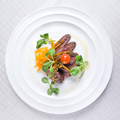 Image showing fried meat with vegetables on the plate isolated on white