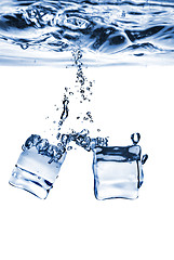 Image showing ice cubes dropped into water with bubbles isolated on white