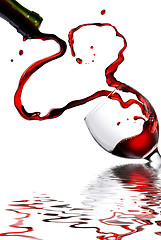 Image showing Heart from pouring red wine in goblet isolated on white