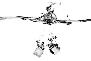 Image showing ice cubes dropped into water with splash isolated on white